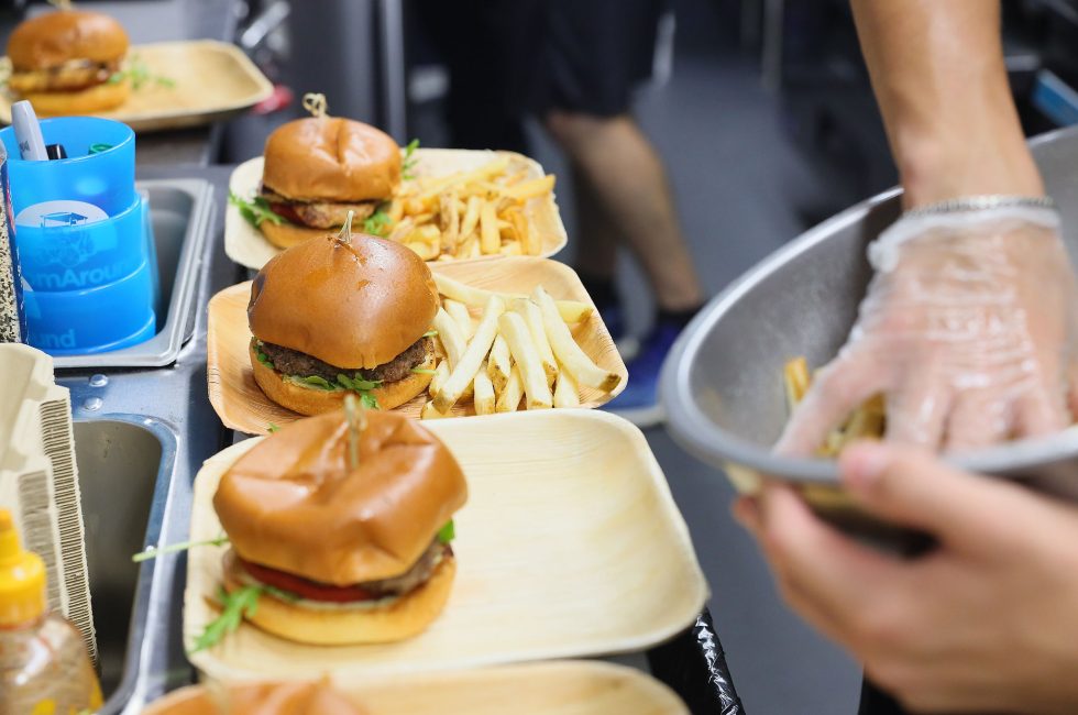 A counter with several burgers and fries on paper trays