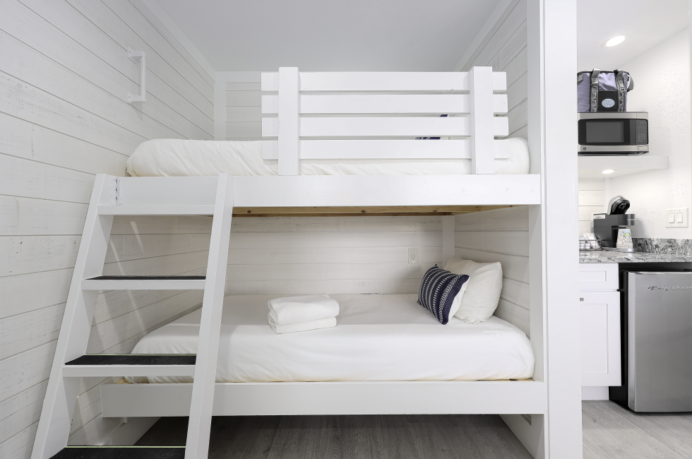 A room with a bunk bed and a kitchenette